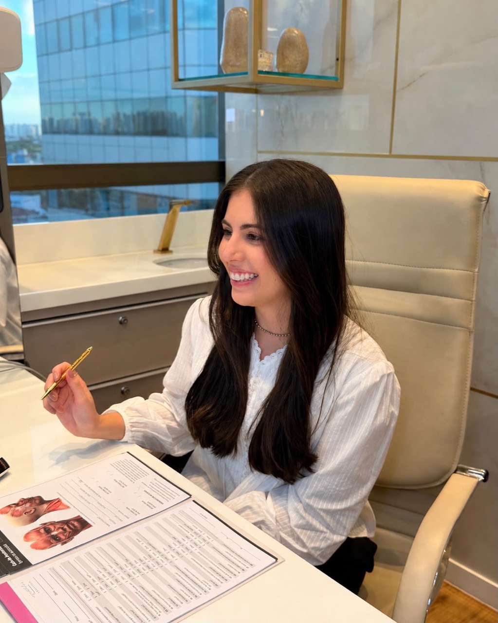 Steffanie Vasconcelos à mesa, com material de anatomia.